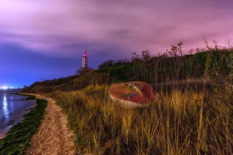 Boat on the beach at night. Lighthouse in the back. Beautiful landscape. Stock Photos