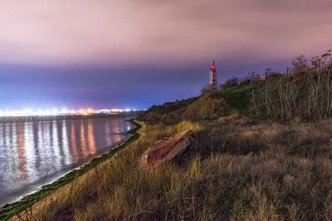 Boat on the beach at night. Lighthouse in the back. Beautiful landscape. Stock Photos