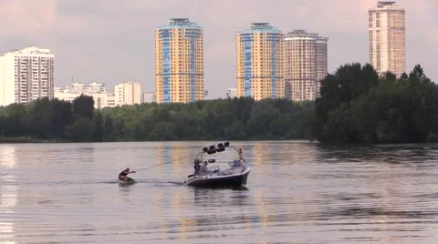 Boat begin to float and drag water-skier by the river Stock Footage 66526228