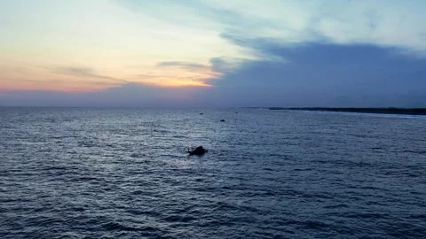 Boat beneath pastel twilight clouds on ocean Stock Footage 335440599