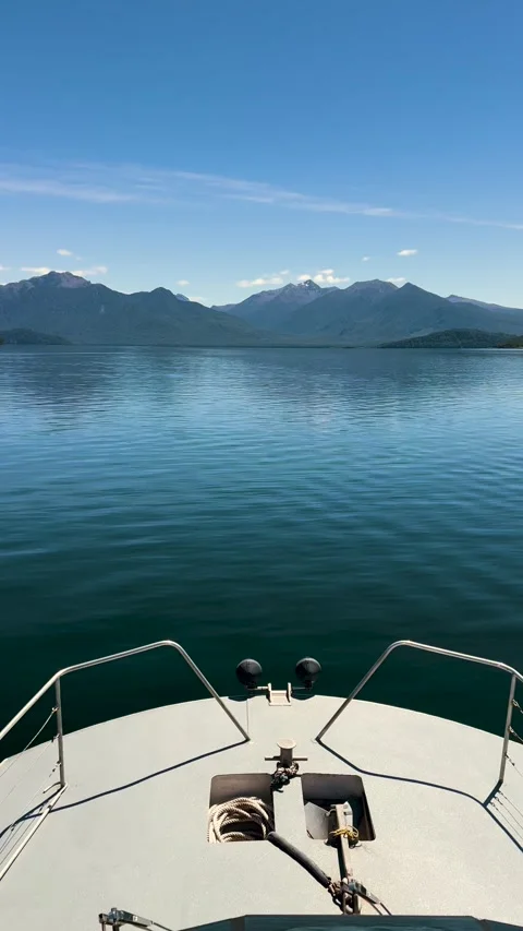 Boat bow view cruising calm lake Manapouri, New Zealand - vertical Stock Footage 342234845