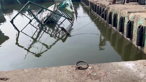 Boat is broken and is submerged into half by the side of river Video stock 261784401