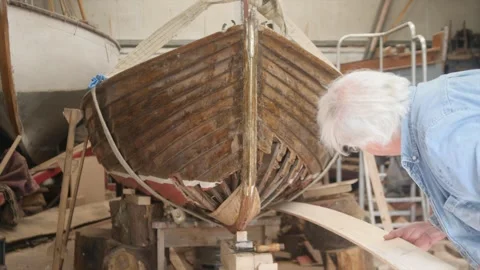 Boat builder dry fitting hull plank to wooden clinker boat Stock Footage 338186744