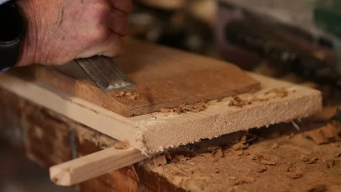 Boat building creating a scarf joint using a chisel Iroko wood Stock Footage 302715379