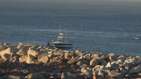 Boat buying bait fish from men on shore. Los Cabos, Mexico. Stock Footage 109138652