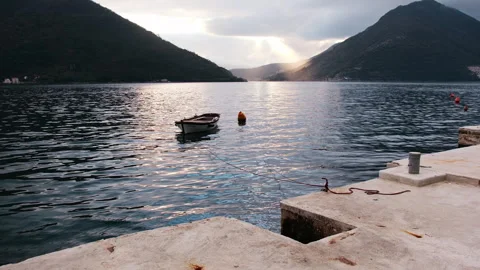 Boat on Calm Bay with sun rays between mountains, Perast, Montenegro 库存影片 337302654
