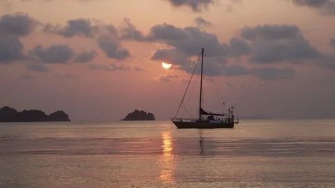 Boat on the calm waves on the pink sunset in the ocean water. Stock Footage 107862841