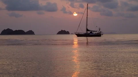 Boat on the calm waves on the pink sunset in the ocean water. Stock Footage 107862937