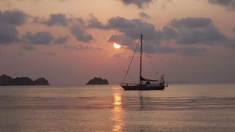 Boat on the calm waves on the pink sunset in the ocean water. Stock Footage 107863304