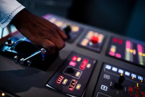 Boat captain hands navigating and moving instruments in the cockpit. Stock Photos