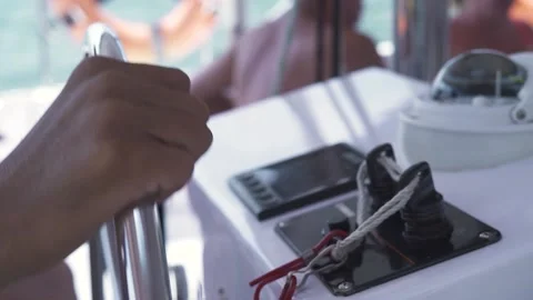 Boat captain's hand controlling the steering wheel. Close up, slow motion shot. Video stock 136429171