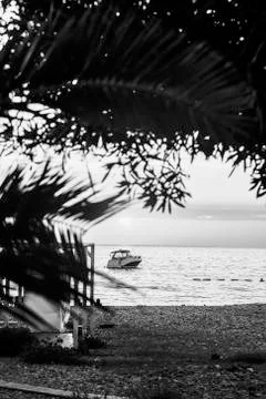 Boat off the coast at sunset Stock Photos