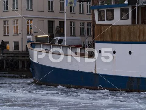 A boat cought in the ice in Nyhavn Copenhagen during hard winter Stock Photos