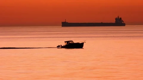 Boat crossing frame orange sky sunset Stock Footage 144353049