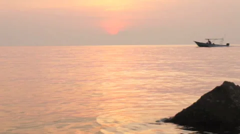 Boat crossing ocean during sunset Stock Footage 32325541