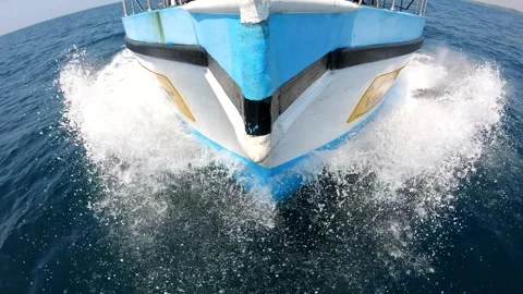 Boat cutting through waves, showcasing powerful motion and splashes, with Stockbeeldmateriaal 330591530