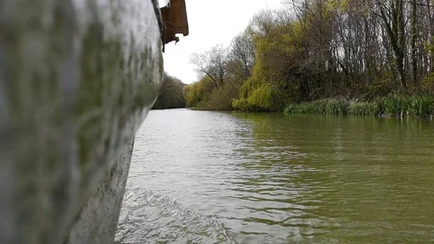 By the boat down the river along the coast overgrown with the wood 動画素材 107162149
