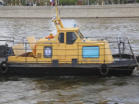 Boat  dragging trees across river urban surrounding Stock Footage 77583554