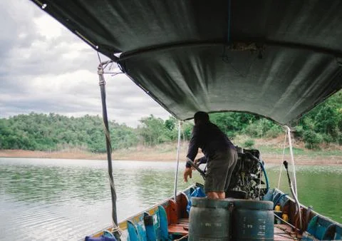 Boat driver was on the back of long tail boat in speed floating on green wate Stock Photos