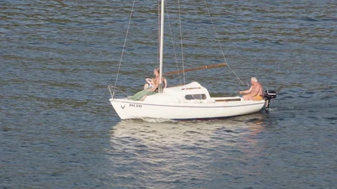 A boat with an elderly couple on board sails on a lake. 스톡 동영상 123638943