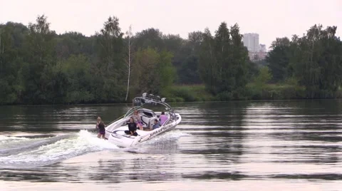 Boat float and drag water-skier by the river Stock Footage 66526223