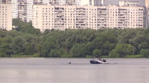 Boat float around water-skier swiming in the river on background of green forest Stock Footage 67866166