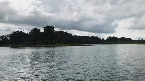 A boat floating along a river next to a body of water 動画素材 156015695