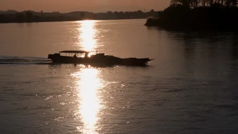 A boat floating along a river next to a body of water 库存影片 156849231