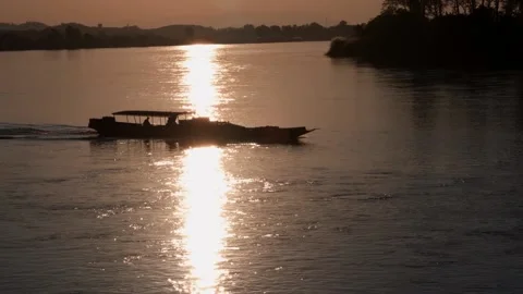 A boat floating along a river next to a body of water 库存影片 157872688