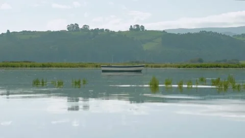 Boat floating calmly with reflection in slow motion Stock Footage 297791956
