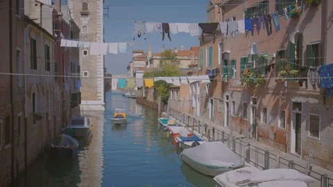 Boat floating in the Canal in Venice drying underwear on the rope Italy sunny Stock Footage 97374239