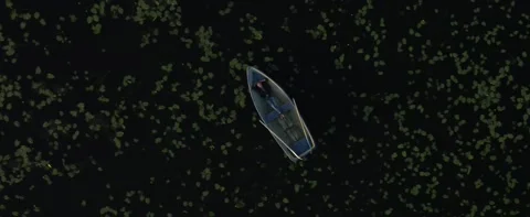 A boat is floating on dark water Stock Footage 141886252