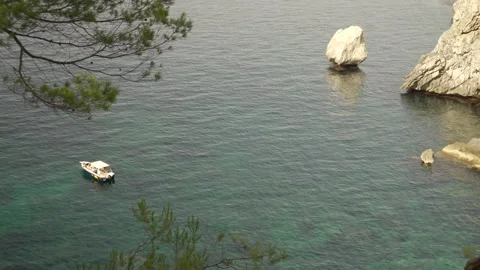 Boat floating by isolated Mediterranean rock formations Video stock 160982252