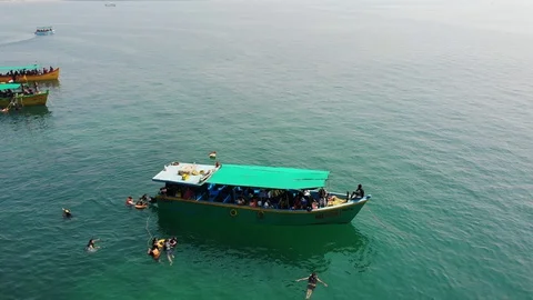 Boat Floating on the Ocean around People doing Swimming at South Goa Beach Stock Footage