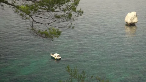 Boat floating over shallow blue sea off Mediterranean island Stock Footage 160981783