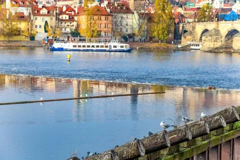 A boat is floating on a river with a bridge in the background in Prague Cze.. Foto stock