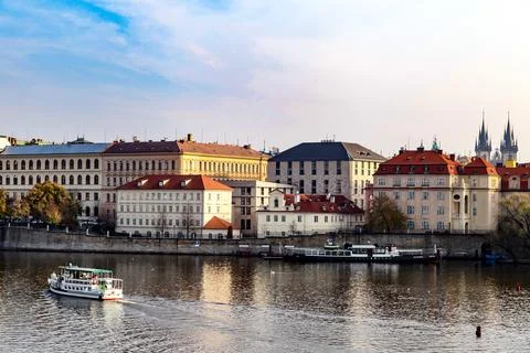 A boat is floating on a river in front of a city in Prague Czech Republic Stock Photos