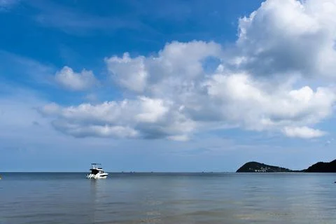 A boat is floating on the water in front of a cloudy sky Stock Photos