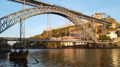 Boat floats in Douro River as tram passes over Luis I Bridge, Porto, Stock Footage 119005904