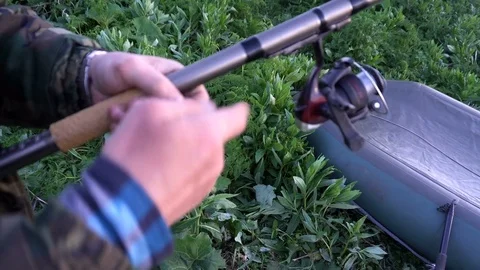 Boat in focus in the background, the foreground is out of focus fishing rod in Stock Footage 76139554