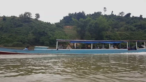 Boat full of tourists sails down the river, woman empties water, shot in motion Vídeos de archivo 81606882