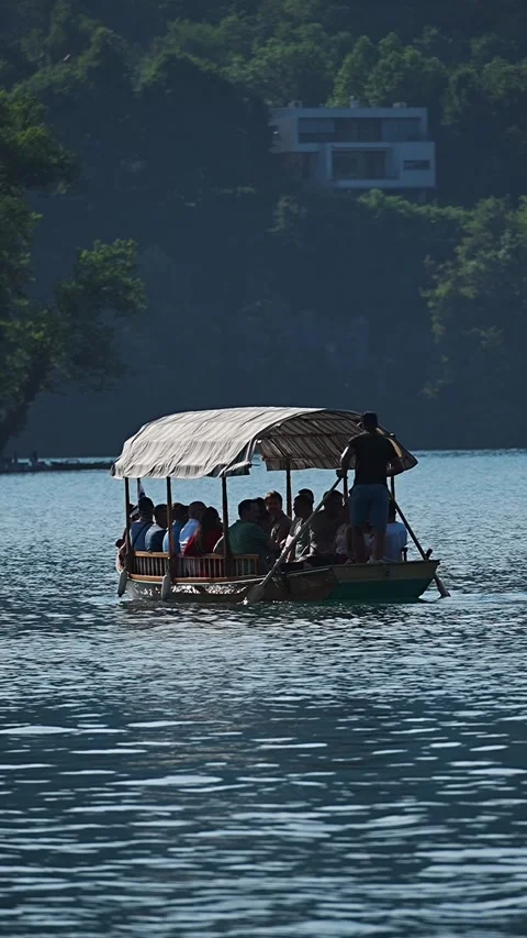 Boat glides across calm waters with a thatched roof Stock Footage 345538888