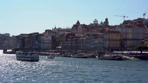 A boat glides on a river, reflecting a vibrant city skyline Stock Footage 280605470