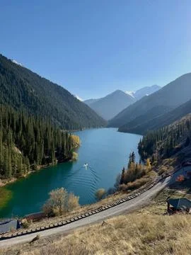 Boat Glides Through Emerald Mountain Serenity Stock Photos