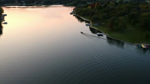 Boat Gliding towards the Sunset on a Summer Lake Stock Footage 145242232
