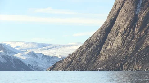 Boat heading down the sea in front of snowy mountains. Видео 68982629