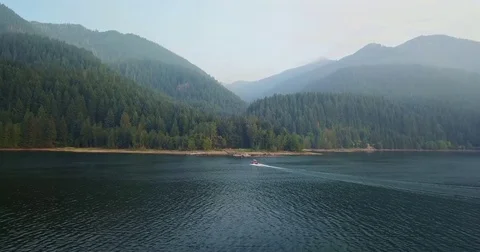 Boat heading toward Forest Beach in Cascade Mountaints Stock Footage 79166495
