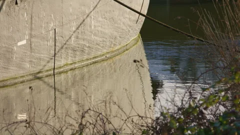Boat hull reflection with mooring chain and calm water surface Stock Footage 325954749