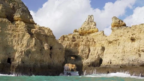 Boat jumping on adventure riding through natual rock arch with massive waves Stock Footage 273673167