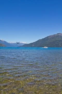 Boat at the lake side with mountain range in the background close to El Bol.. Stock Photos